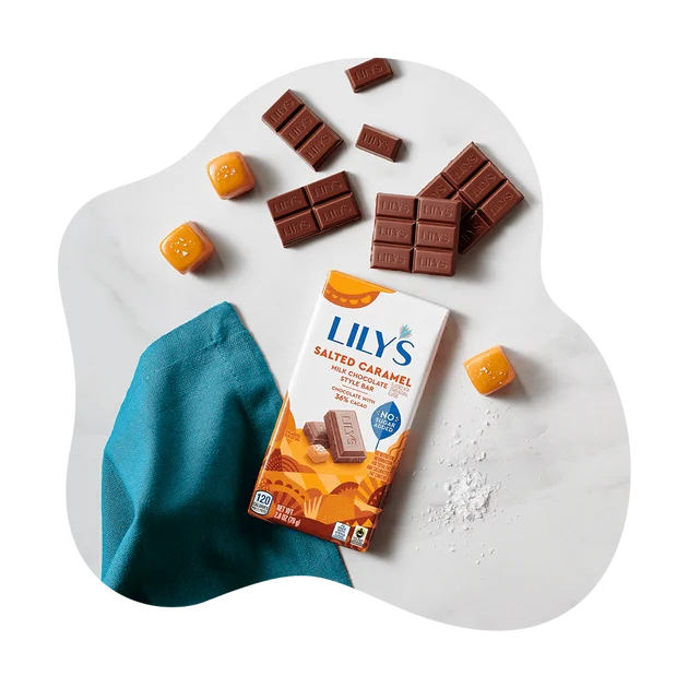 Lily's Salted Caramel Milk Chocolate Style Bar beside chocolate pieces and caramel cubes